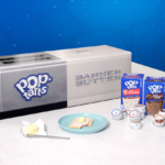 Image is of a toaster oven with the Pop-Tarts Logo, several boxes of Pop-Tarts, and a plate with butter on it